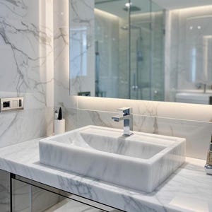 Peut inclure: Une salle de bain moderne avec un lavabo rectangulaire en marbre et un robinet chromé. Le lavabo est posé sur un plan de travail en marbre, avec des murs en marbre et un grand miroir. Le design est minimaliste et luxueux.
