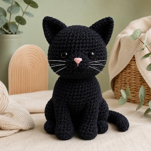 May include: A black crocheted cat plush toy featuring a small pink stitched nose, white thread whiskers, and large black plastic safety eyes. The cat is depicted in a seated position with its tail curled to the side, showcasing a textured yarn finish.