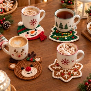 Könnte beinhalten: Vier Keramiktassen mit Heißgetränken stehen auf gehäkelten Untersetzern. Die Untersetzer zeigen festliche Motive wie einen Schneemann, einen Weihnachtsbaum, ein Rentier und eine Schneeflocke. Jede Tasse hat ein weihnachtliches Muster.