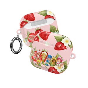 Puede incluir: Funda rosa para AirPod con diseño de fresas y flores. La funda tiene un mosquetón plateado. El diseño incluye fresas rojas, flores blancas, hojas verdes y personajes de dibujos animados.
