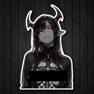 May include: A sticker depicting a female demon with black hair, orange eyes, and horns. She is dressed in a black outfit with a cross pendant. The image has a white border and is set against a dark wood grain background.