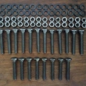 May include: A set of 20 silver-toned bolts with square heads and matching washers. The bolts are arranged in two rows of ten, with the washers placed on top of the bolts.