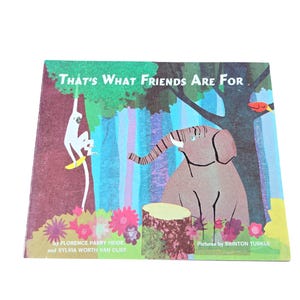 May include: A children's book titled "That's What Friends Are For" with a colorful illustration. The cover features a monkey, an elephant, and a forest scene. The book's title is in green, and the authors and illustrator are also listed.