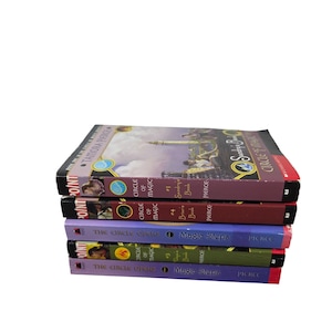 Peut inclure: Une pile de cinq livres aux couvertures colorées. Les titres incluent "Circle of Magic" et "Magic Steps" de Tamora Pierce. Les livres sont de couleurs variées, dont le violet, le vert et le rouge, avec l'empreinte Point visible.
