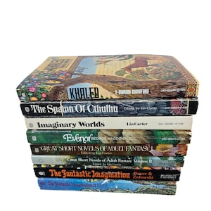May include: A stack of vintage paperback books with colorful covers. Titles include "Khaled," "The Spawn of Cthulhu," and "Imaginary Worlds." The books are stacked on top of each other, with the spines and covers visible. The books are in good condition.