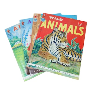 May include: A stack of four vintage children's books with colorful covers. The top book is red and features a tiger with the title "Wild Animals, A Rand McNally Book". The other books are blue, green, and yellow with illustrations of children and animals.