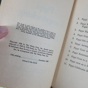 Puede incluir: Un libro titulado "Pippi Calzaslargas" de Astrid Lindgren. La portada del libro presenta una ilustraci&oacute;n colorida de Pippi Calzaslargas, una ni&ntilde;a con trenzas rojas y pecas, de pie sobre una roca con los brazos extendidos. El libro est&aacute; publicado por The Viking Press, Inc. y TAB Books, Inc.