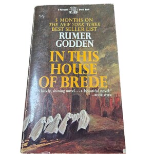 May include: A vintage paperback book titled "In This House of Brede" by Rumer Godden. The cover features text that reads "5 Months on the New York Times Best Seller List." The cover art depicts figures in white robes in front of a building.