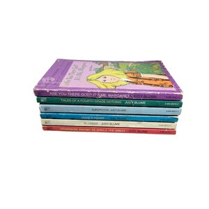 May include: A stack of Judy Blume books, including "Are You There God? It's Me, Margaret" and "Tales of a Fourth Grade Nothing." The books have colorful covers with titles and author names visible. The books are stacked on top of each other.