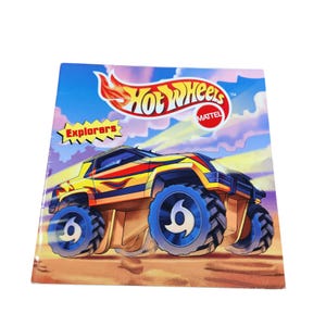 May include: A yellow Hot Wheels toy car with red and orange flames on the side. The car has blue wheels with a black swirl design. The car is on a sandy background with a blue sky. The text "Hot Wheels" and "Explorers" is on the cover of the book.
