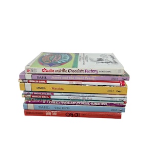 以下が含まれることがあります： 「チャーリーとチョコレート工場」や「マチルダ」など、ロアルド・ダールの本が積み重ねられています。背表紙にはタイトルと著者の名前が記載されています。本は白い背景に積み重ねられています。