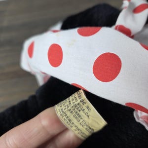 Pu&ograve; includere: Un peluche nero con un fiocco bianco a pois rossi. L'etichetta recita "Walt Disney Company" e "Minnie 17 Star". Il giocattolo &egrave; realizzato con materiali sintetici.