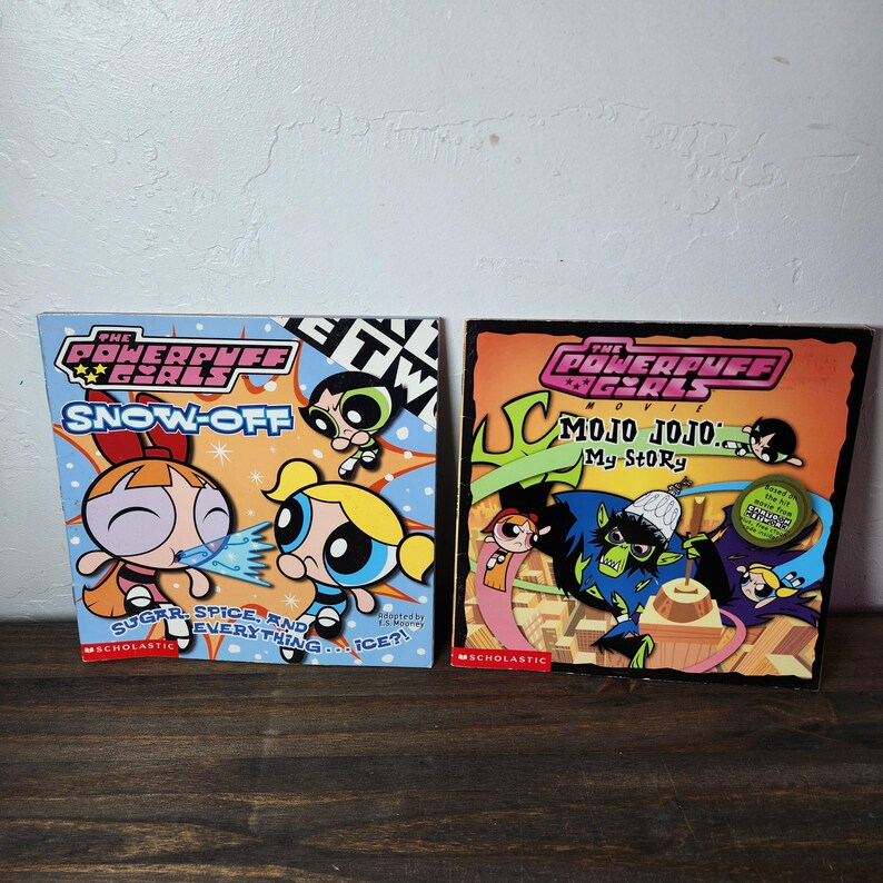May include: Two paperback books featuring the Powerpuff Girls. The book on the left is titled "Snow-Off" and features the Powerpuff Girls in a snowy scene. The book on the right is titled "Mojo Jojo: My Story" and features Mojo Jojo, the Powerpuff Girls' nemesis, in a city scene.