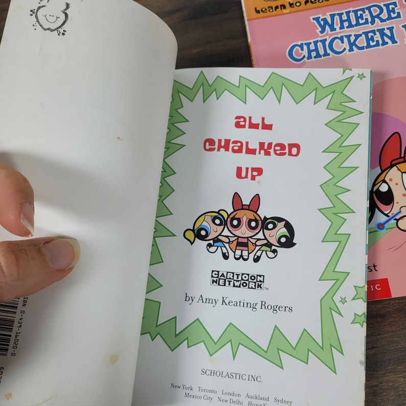 May include: A green and white book cover with the title "All Chalked Up" featuring the Powerpuff Girls cartoon characters. The book is published by Scholastic and features the Cartoon Network logo.
