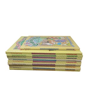 Puede incluir: Una pila de libros infantiles con cubiertas amarillas. Los títulos incluyen "The Just-Right Family", "Xavier's Fantastic Discovery" y "The Shyest Kid in the 'Patch". Los libros son publicados por Parker Brothers y presentan ilustraciones coloridas.