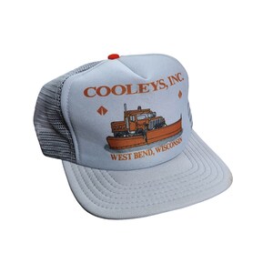 Op de afbeelding: Lichtblauwe truckerpet met een wit voorpaneel. Het heeft de tekst "COOLEY'S, INC" en een oranje illustratie van een sneeuwploeg. De pet heeft een grijze mesh achterkant en een gebogen klep. De tekst "WEST BEND, WISCONSIN" staat ook op de voorkant.
