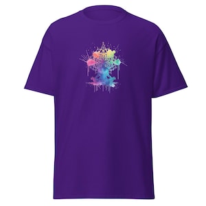 May include: A purple short-sleeve t-shirt featuring a central graphic of a person in a seated meditation pose. The design incorporates a colorful watercolor-style mandala pattern with paint splatters in shades of blue, pink, yellow, and green.