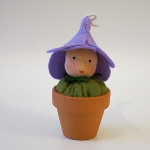 May include: A purple felt flower pot doll with a green felt stem and a brown felt pot.
