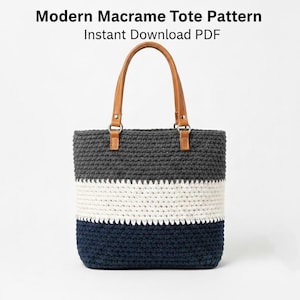 May include: A handmade macrame tote bag with a color-block design. The bag features a gray top, a white middle section, and a navy blue bottom. It has brown leather handles and the text "Modern Macrame Tote Pattern Instant Download PDF".