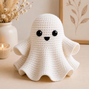 Può includere: Una statuetta a forma di fantasma lavorata all'uncinetto color crema, dotata di testa arrotondata, due grandi occhi di sicurezza in plastica nera e una piccola bocca triangolare nera. Il corpo presenta una trama a maglia strutturata.