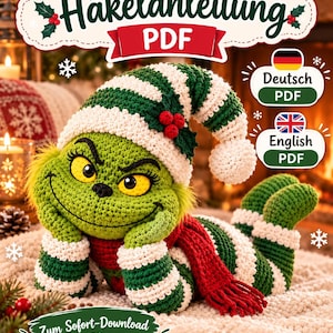 May include: A crochet pattern PDF featuring a green creature with yellow eyes, wearing a green and white striped hat with red berries and a red scarf. The text reads Häkelanleitung PDF, Deutsch PDF, English PDF, and Zum Sofort-Download.