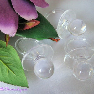 May include: Three clear plastic baby pacifier shaped favors for a baby shower or other event.