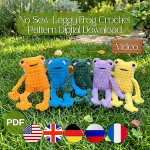 May include: Five colorful crochet frog toys in orange, blue, green, purple, and yellow are displayed on green grass. The image includes text that reads "No Sew Leggy Frog Crochet Pattern Digital Download" and "Video".