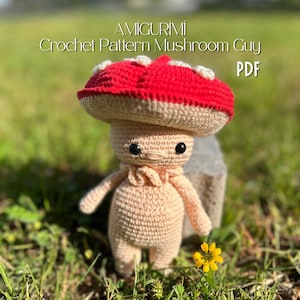 May include: A crocheted mushroom figure with a red cap and beige stem and body. The mushroom has a smiling face with black eyes. The text "AMIGURUMI Crochet Pattern Mushroom Guy PDF" is displayed above the figure.