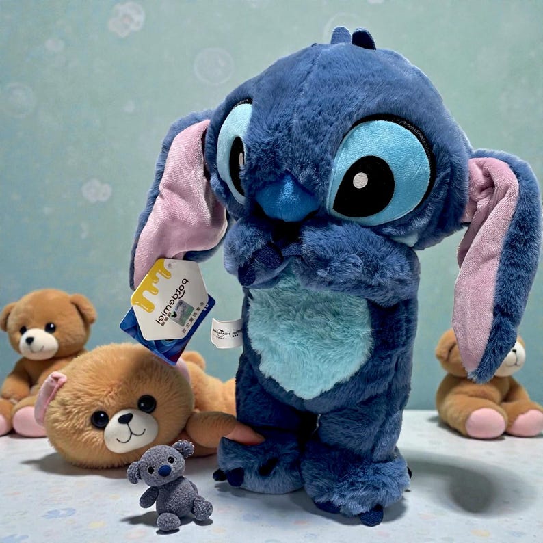 May include: A plush blue Stitch doll with large eyes, ears, and a tag. Several brown teddy bears and a small gray bear are also visible. The Stitch doll is the focal point, with a soft, textured appearance.