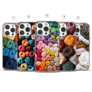 Puede incluir: Cinco fundas para teléfono con diseños de ovillos de lana coloridos. Cada funda presenta una disposición diferente de colores de hilo, incluyendo azul, naranja, rosa, morado, amarillo, marrón y verde. Las fundas son de material transparente.