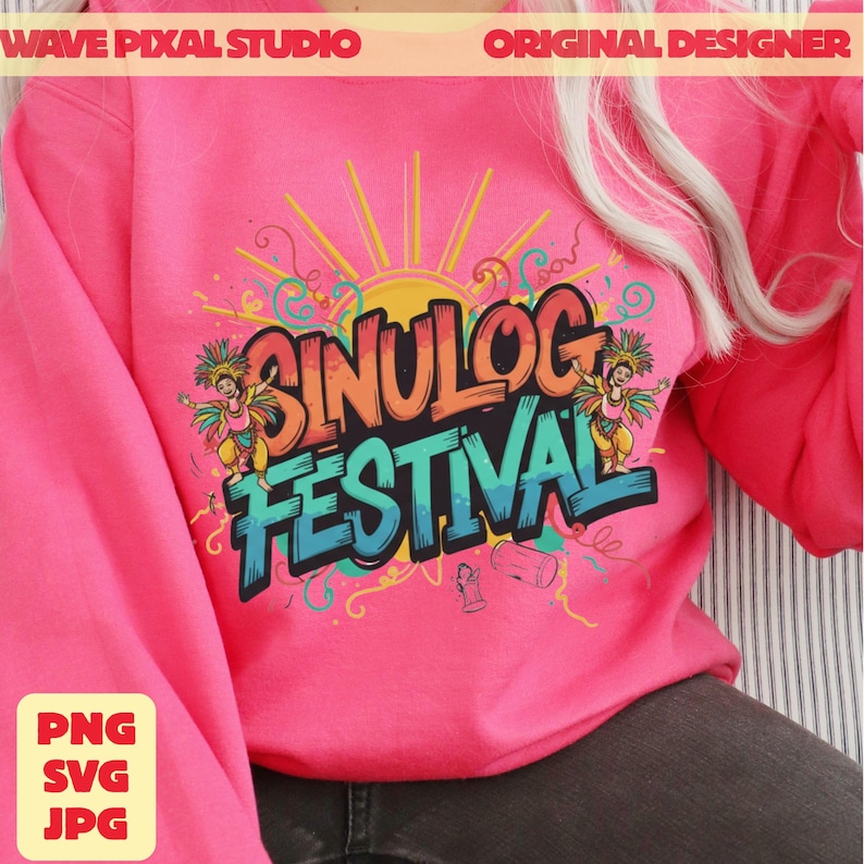 May include: A bright pink sweatshirt featuring the words "Sinulog Festival" in colorful, stylized lettering. The design includes a sun, dancers, and decorative swirls. The sweatshirt also has the text "WAVE PIXAL STUDIO" and "ORIGINAL DESIGNER".