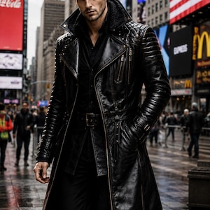 Puede incluir: Una gabardina larga de cuero negro con diseño acolchado en los hombros, cuello de solapa ancha, cinturón en la cintura y bolsillos verticales con cremallera. Se lleva sobre una camisa negra y pantalones negros, creando un conjunto oscuro y elegante.