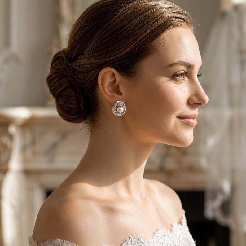 Elegant freshwater pearl bridal earrings worn by a bride with an updo hairstyle and white wedding dress.