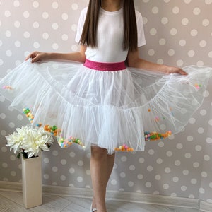 Whimsical Charm: Our handmade kids' skirt boasts delightful white pompoms for a playful touch of elegance!