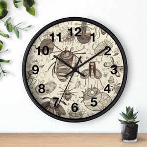 May include: A round wall clock with a black frame. The clock face features a beige background with various insect illustrations in shades of brown. Black hands indicate the time. Numbers 1 through 12 are displayed.