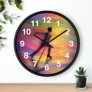 May include: Black-framed wall clock featuring a colorful abstract background with a figure skater in motion. White numerals mark the hours. The clock hands are black. A decorative item for a home or office.
