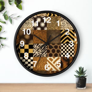 May include: A round wall clock with a black frame and a patchwork design. The clock face features various animal print patterns in shades of brown, tan, and black. White numbers mark the hours. The clock hands are black.