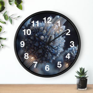 May include: A round black wall clock with a unique design. The clock face features a blue and white crystal-like pattern. White numerals mark the hours. The clock is on a wooden surface with plants in the background.