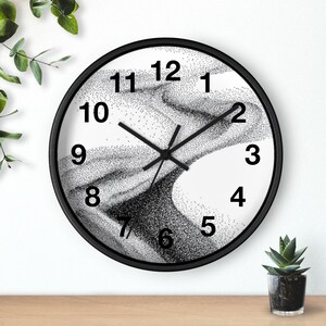 May include: A round wall clock with a black frame. The clock face features a black and white abstract design with black numerals. The clock hands are black.