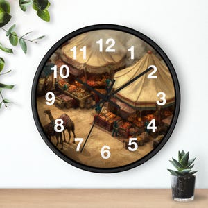 May include: A round wall clock with a black frame. The clock face features a detailed illustration of a marketplace with tents, stalls, and camels. White numerals mark the hours. The clock hands are black.