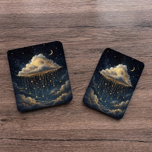 May include: Two rectangular coasters featuring a dark night sky with a large, glowing cloud raining golden stars. The design includes a crescent moon and scattered smaller stars against a deep blue and black background, creating a celestial scene.