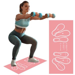 May include: A woman doing squats with dumbbells on a pink exercise mat. The mat has white outlines of feet and text. The woman is wearing a blue sports bra, gray leggings, and white sneakers. She is holding two blue and brown dumbbells.