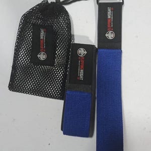Puede incluir: Una bolsa de malla negra y dos correas de ejercicio azules con el texto "FLIPPING WEIGHT" en rojo y blanco. Las correas est&aacute;n hechas de un material texturizado y tienen una banda negra con el mismo texto. La bolsa se cierra con un cord&oacute;n negro.