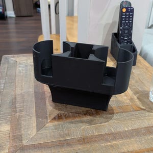 Könnte beinhalten: Ein Set aus drei Keramikbechern mit gesprenkelter, matter Oberfläche. Die Becher sind in den Farbtönen Creme, Hellgrau und Dunkelgrau gehalten. Jeder Becher hat ein schlichtes, minimalistisches Design und einen abgerundeten Henkel.