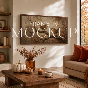 May include: A wall-mounted television displaying a painting of two birds perched on a tree branch. The screen features the text FRAME TV MOCKUP. Below, a wooden coffee table holds a white pumpkin, a smaller gold pumpkin, a vase, and a candle.