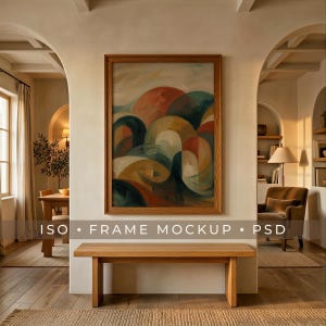 May include: A framed abstract painting with a wooden frame hangs above a wooden bench. The artwork features a colorful, layered design with shades of red, orange, blue, and yellow. The room has a neutral color palette with natural light.