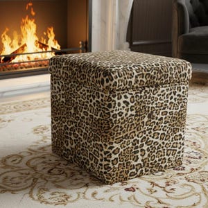 May include: A square ottoman with a leopard print pattern. The ottoman is placed on a patterned rug in front of a fireplace with a burning fire. The color scheme is neutral with brown and beige tones.