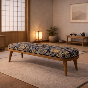 Peut inclure: Banc ovale rembourré avec une structure et des pieds en bois. Le tissu du banc est orné de motifs bleus, jaunes et rouges. Il est posé sur un tapis neutre dans une pièce lumineuse.