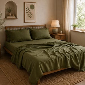 Peut inclure: Un lit avec une parure de lit vert olive, comprenant un drap plat, un drap-housse et deux oreillers rectangulaires assortis. Le lit possède un cadre en bois avec une tête de lit à lattes, placé dans une pièce aux murs neutres et un tapis tissé.