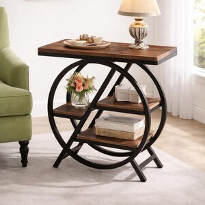 Op de afbeelding: Een decoratieve bijzettafel met een donkerhouten blad en drie planken. De tafel heeft een zwart metalen frame met een cirkelvormig ontwerp. Een lamp, dienblad met kopjes en een vaas met bloemen staan op de tafel. Hoogte: 76 cm.